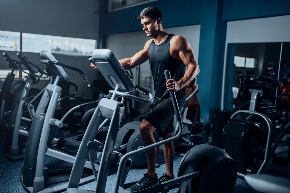 Muscular athlete training legs on exercise machine2. Active sport exercises in gym