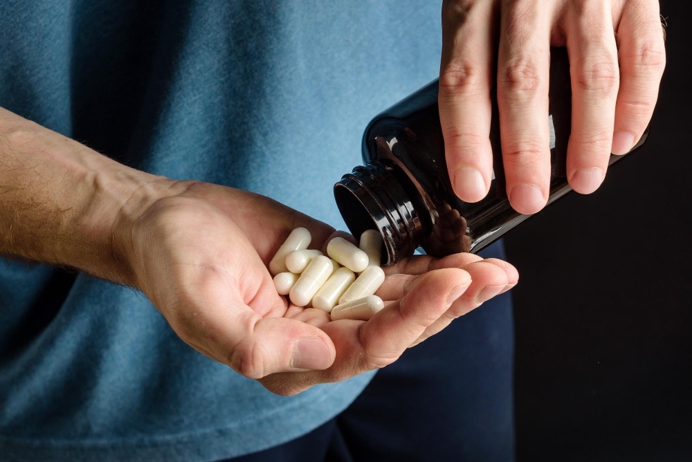 Palm with capsules of sports supplements close up