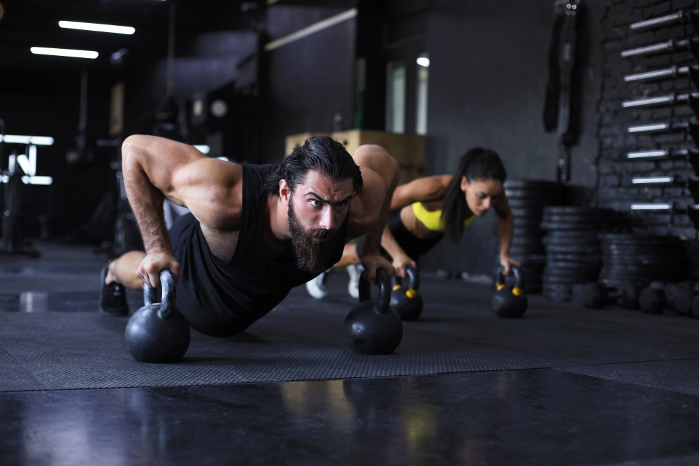 Sporty man and woman doing push up in a gym